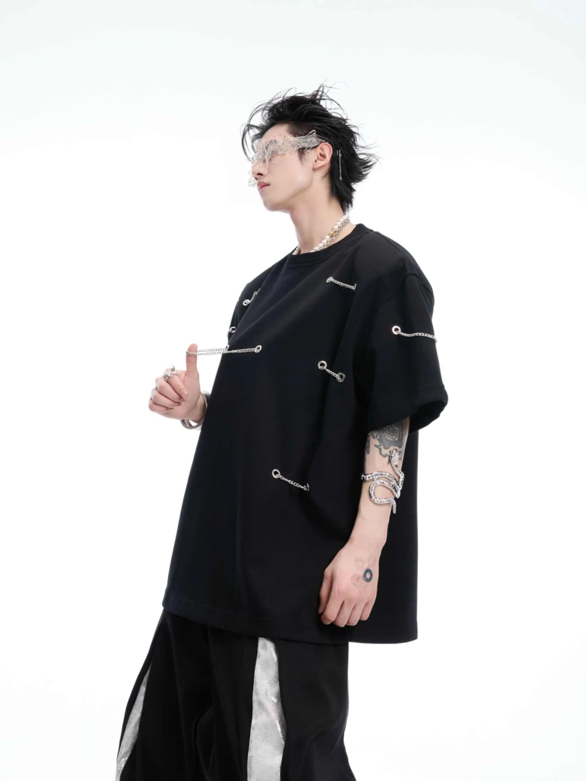 Black T-shirt with padded shoulders and metal chain detail on short sleeves
