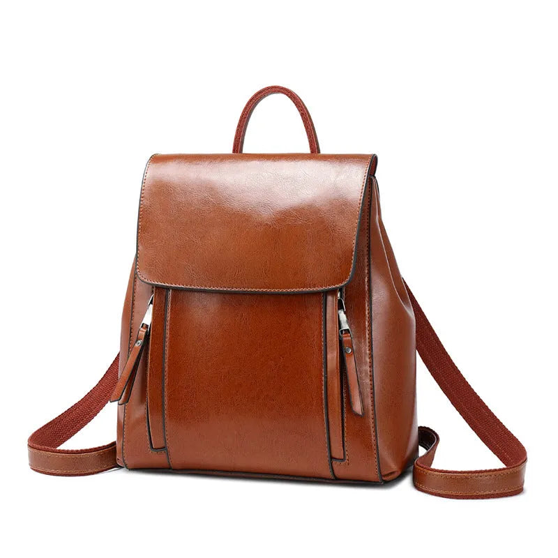 Large genuine cowhide leather women's backpack in black, shown with open cover to reveal internal zipper pockets and phone sleeve.