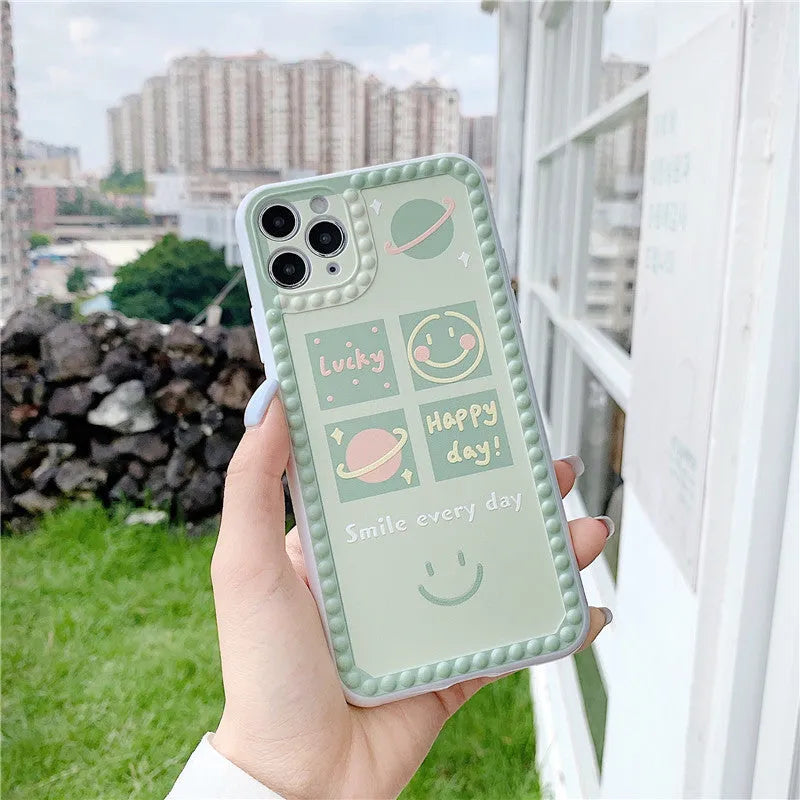 Green iPhone case with geometric smiley face designs and polka dot frames on flexible TPU material