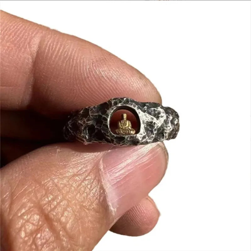 Close-up of a hand-forged copper ring with a Buddha motif and rock texture band on a size 8 finger.