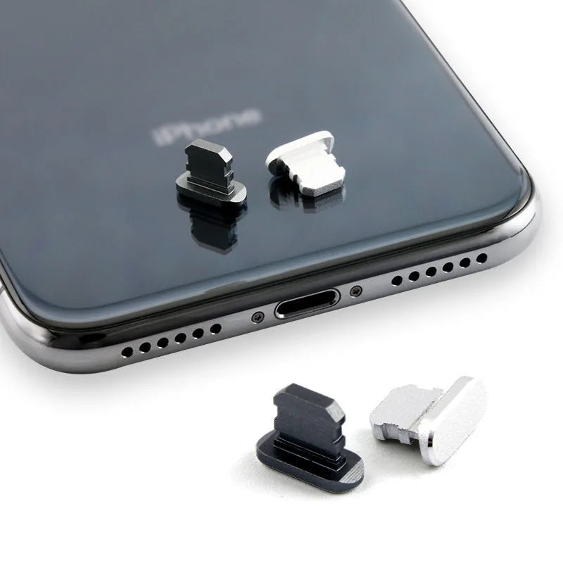 Aluminum alloy iPhone charging port dust plug in rose gold colour on a grey background.