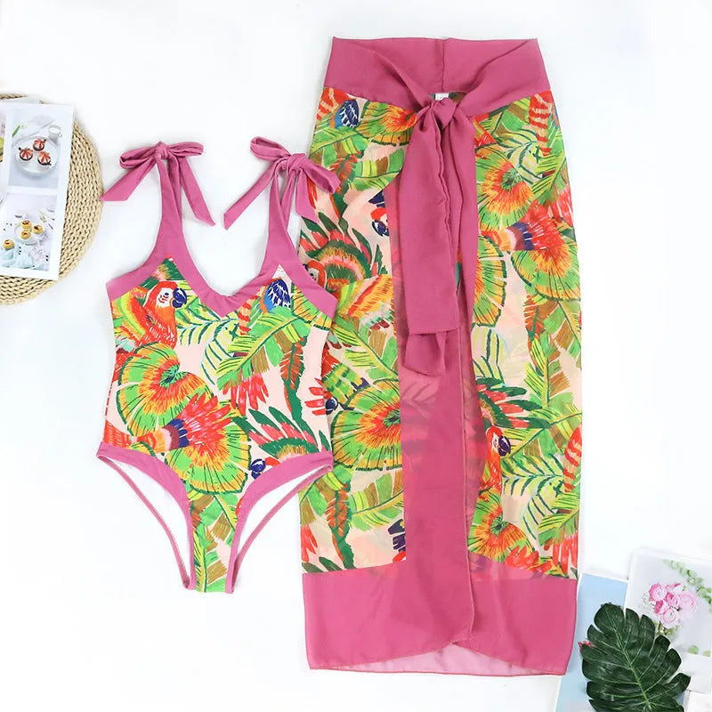 Retro pink floral print one-piece swimsuit with V-neck, skirt, and backless design.