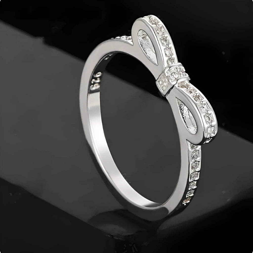 Silver bow-shaped ring with zircon rhinestone crystals on electroplated band