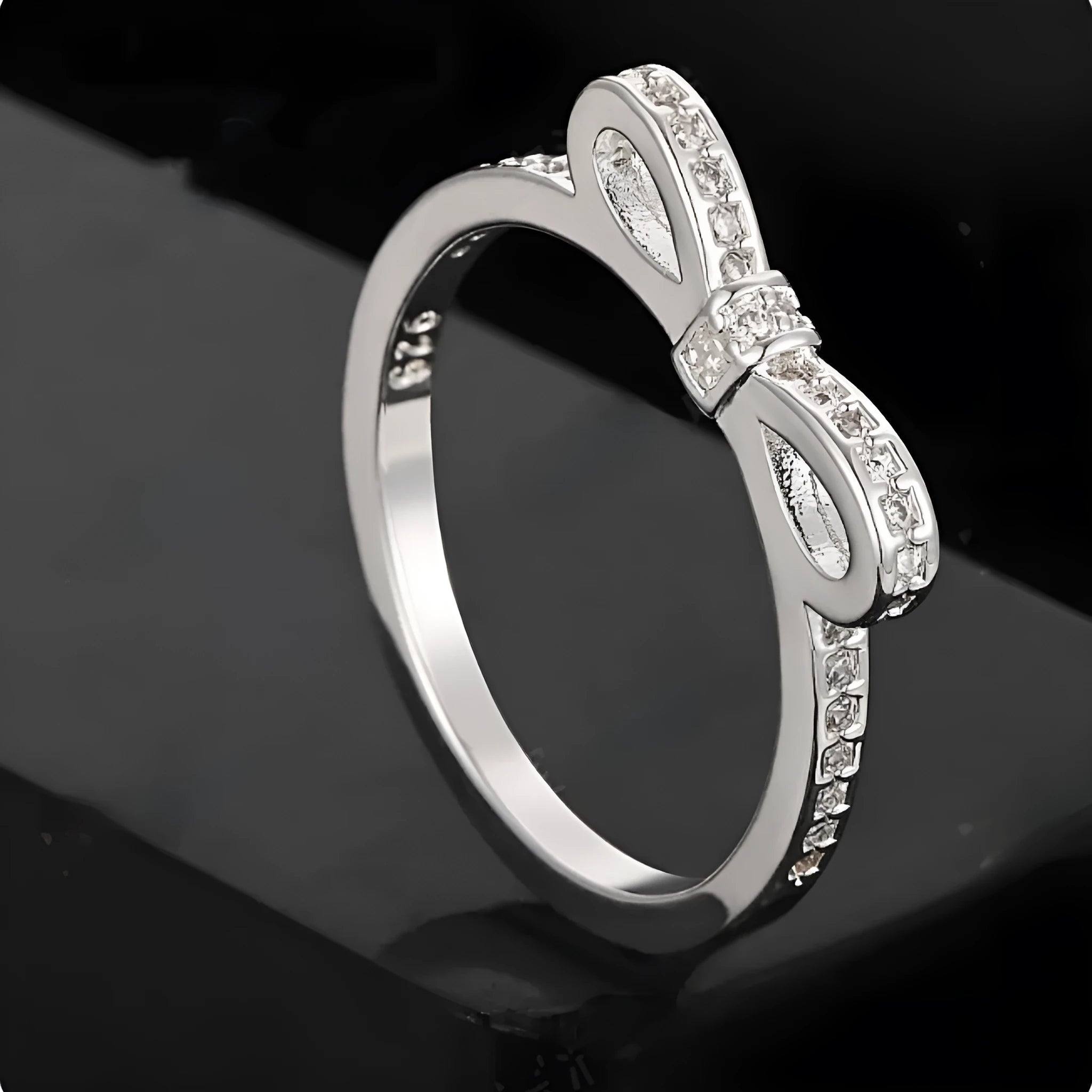 Silver bow-shaped ring with zircon rhinestone crystals on electroplated band