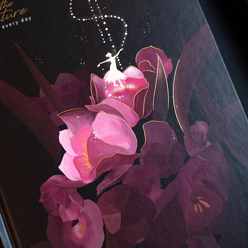 A5 diary book with a luminous purple cover, open to show pages with colour illustrations.