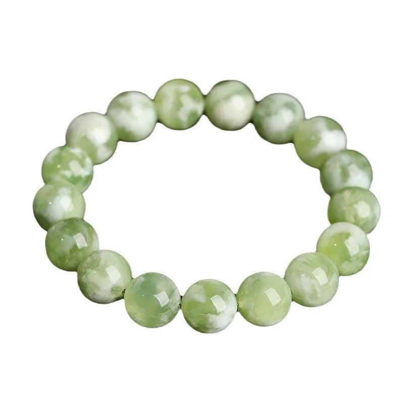 Polished green milk-in-water Xiuyan jade bracelet showing single circle of beads on a wrist.