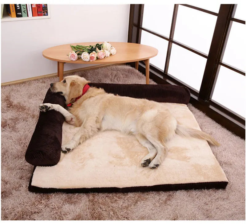 Grey corduroy pet sofa dog bed with bilateral bolsters and a non-slip cloth base on a wooden floor.