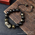 Hand-woven golden obsidian Pi Xiu bracelet with animal zodiac charm on wrist.