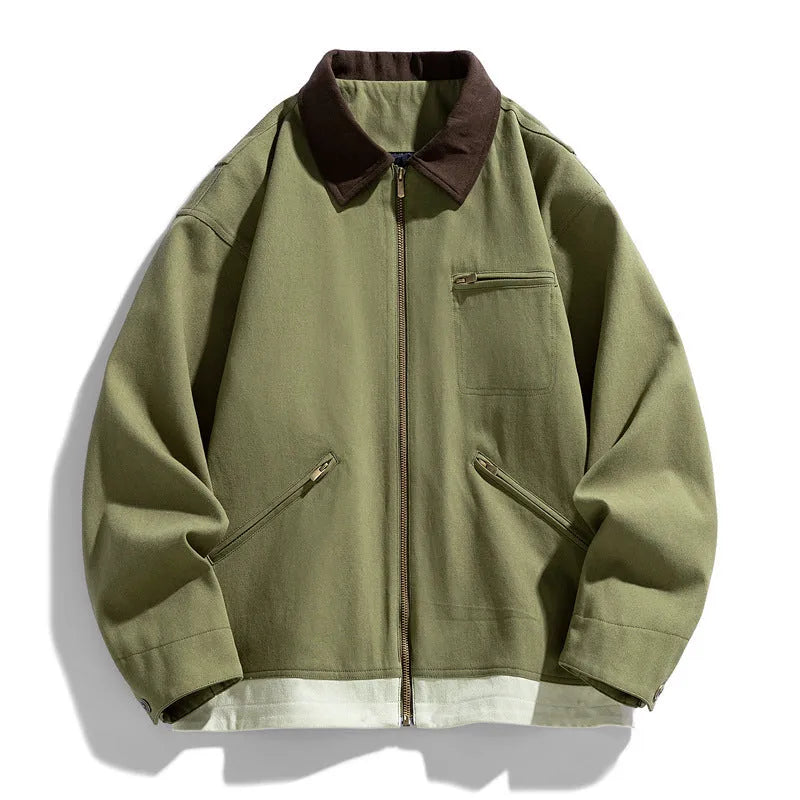 Man wearing a mint green loose-fit retro workwear jacket with dark contrast lapels and side pockets.