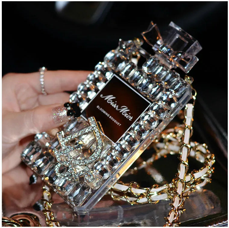iPhone perfume bottle bow phone case in black with matte TPU shell and gold metal chain holding a perfume bottle charm.