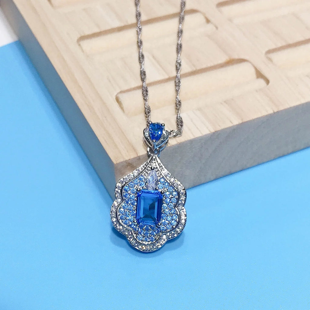 Sea blue geometric copper pendant on a plain background.