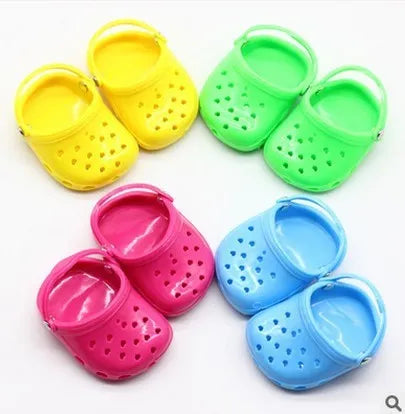 Set of small plastic doll beach slippers in blue, red, yellow, and green colours.