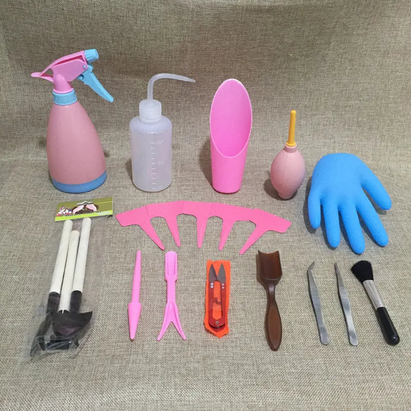 A succulent gardening tool set showing a mini watering can, bucket, tweezers, drip kettle, shovel, rake, and brush on a table.