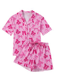 Pink bow print pyjama set with a top and pants, made from lightweight polyester fabric.