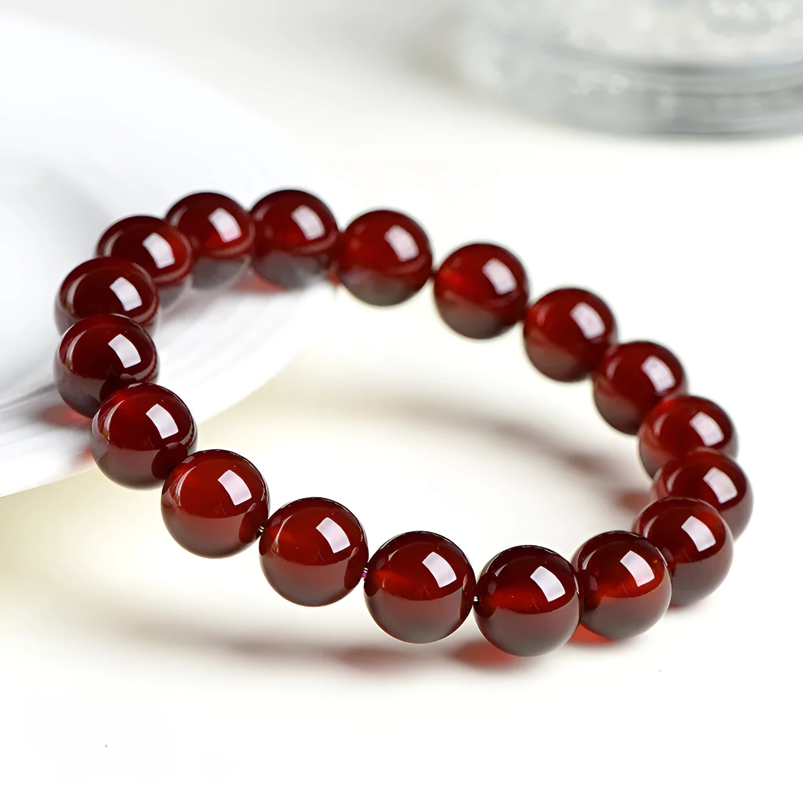 Close-up of a natural orange red garnet crystal bracelet in a unisex retro style with Ruyi design elements.