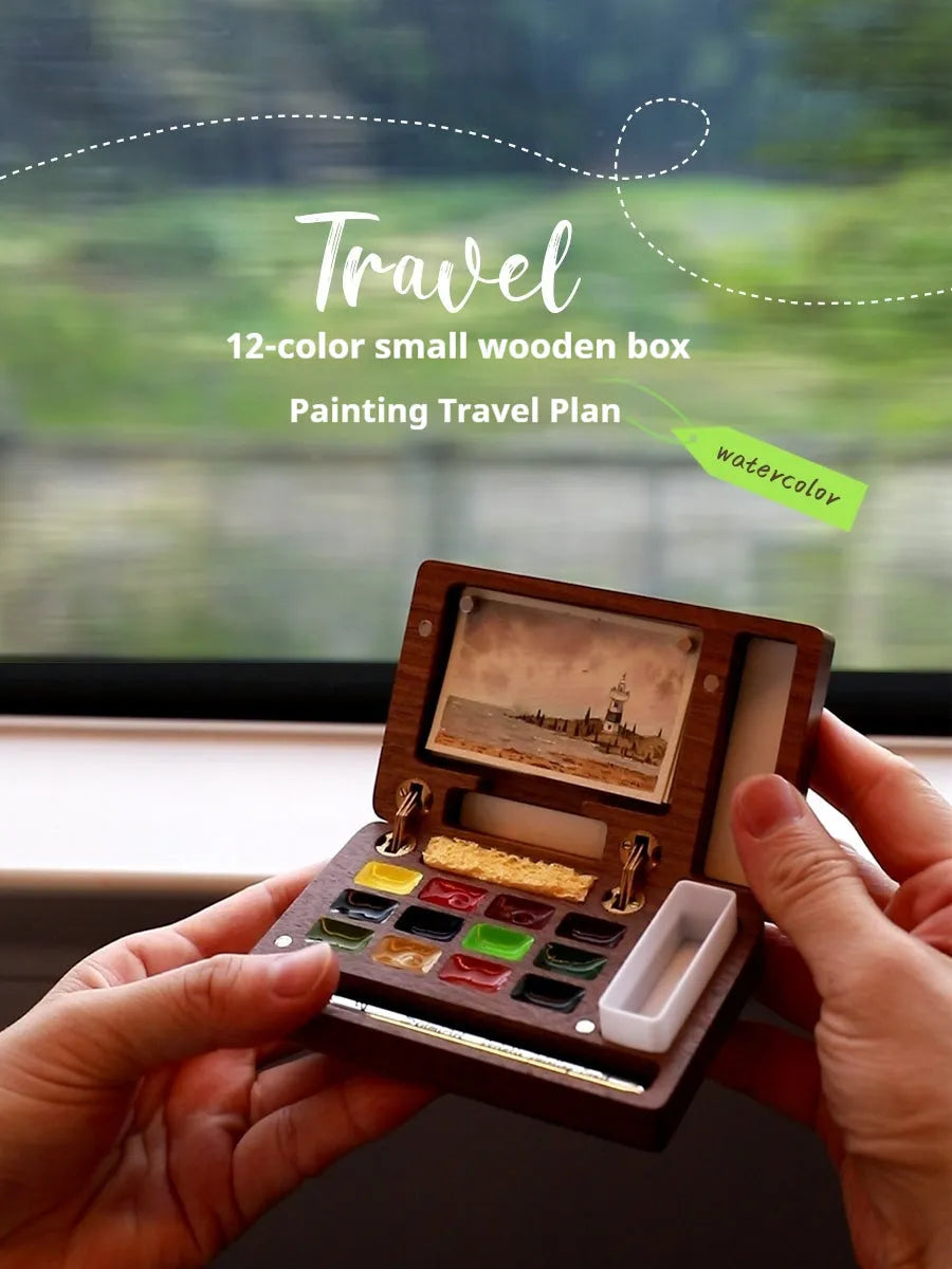 Mini walnut wood watercolour paint box open showing pigment colours inside with paint brush