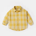 Boy wearing a cotton lattice shirt with animal cartoon print in light blue, long sleeves, casual style.