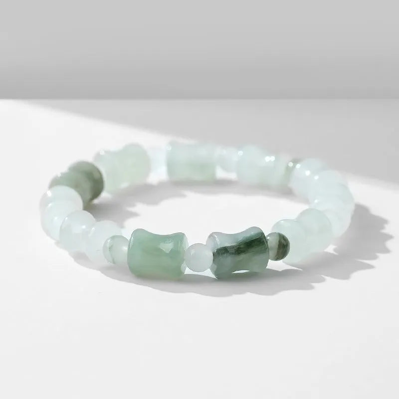Natural jade and coconut shell beaded bracelet with safety lock clasp on wrist.