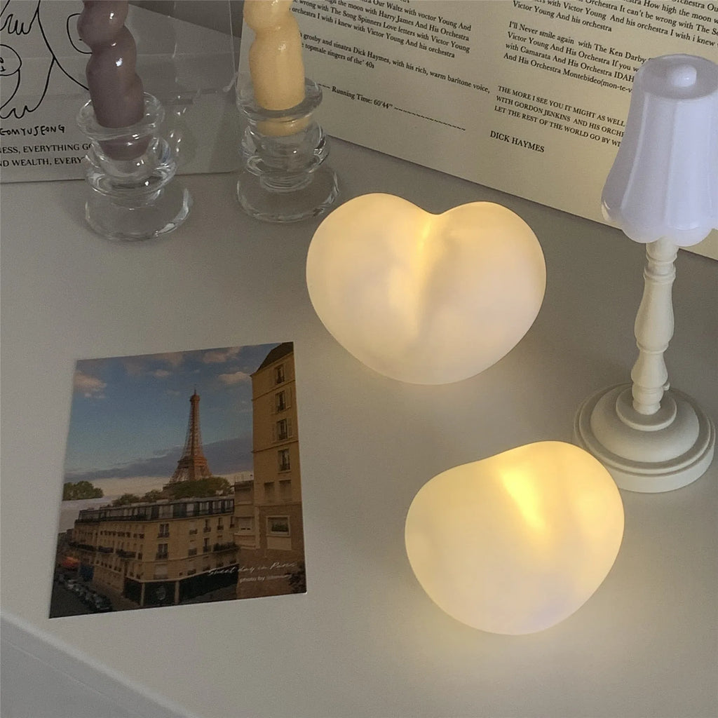 White or pink vinyl trumpet-shaped atmosphere lamp glowing warmly on a surface