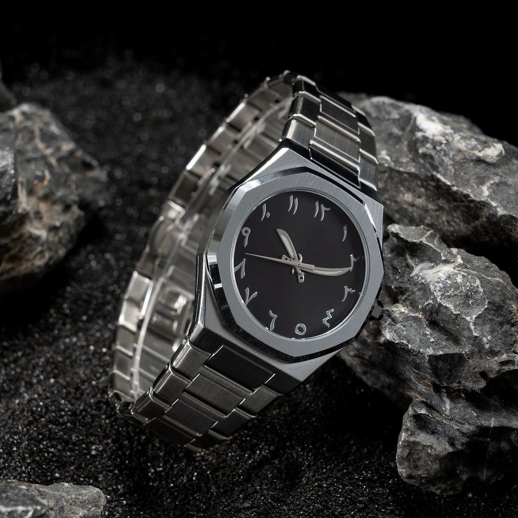 Men's silver and black business casual watch with steel bracelet and analogue dial on a wrist.
