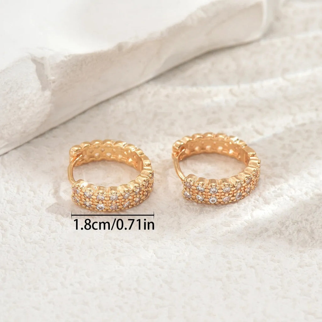 A pair of geometric pattern copper ear studs with round, dot, and ring decorative details.