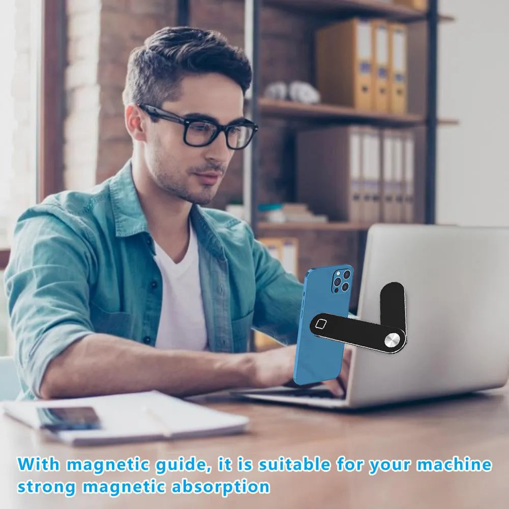 Black aluminium laptop phone holder with magnetic clip attached to a monitor, holding a smartphone