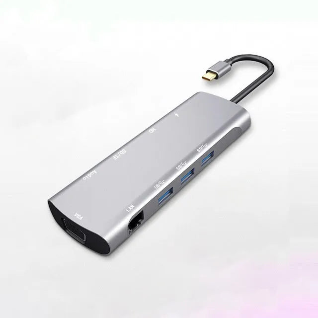Grey aluminium USB-C docking station showing HDMI, VGA, USB, and charging ports.
