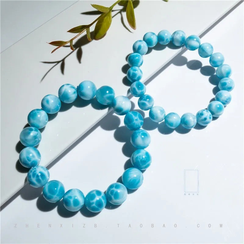 Blue Bodhi bead bracelet with white pearl accents on a plain background.