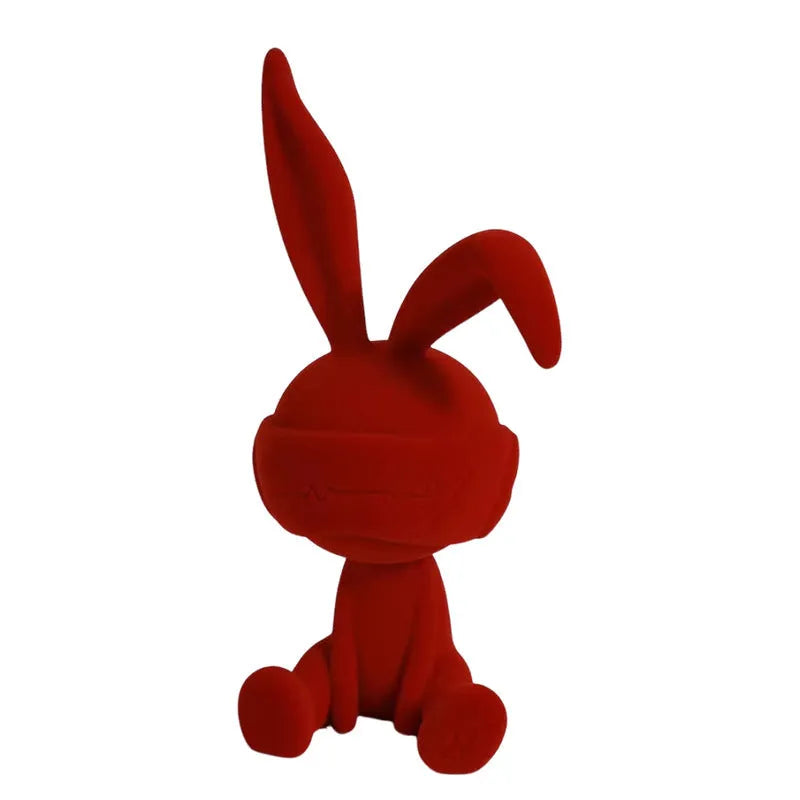 Green suede blindfold rabbit resin table ornament on a wooden surface.