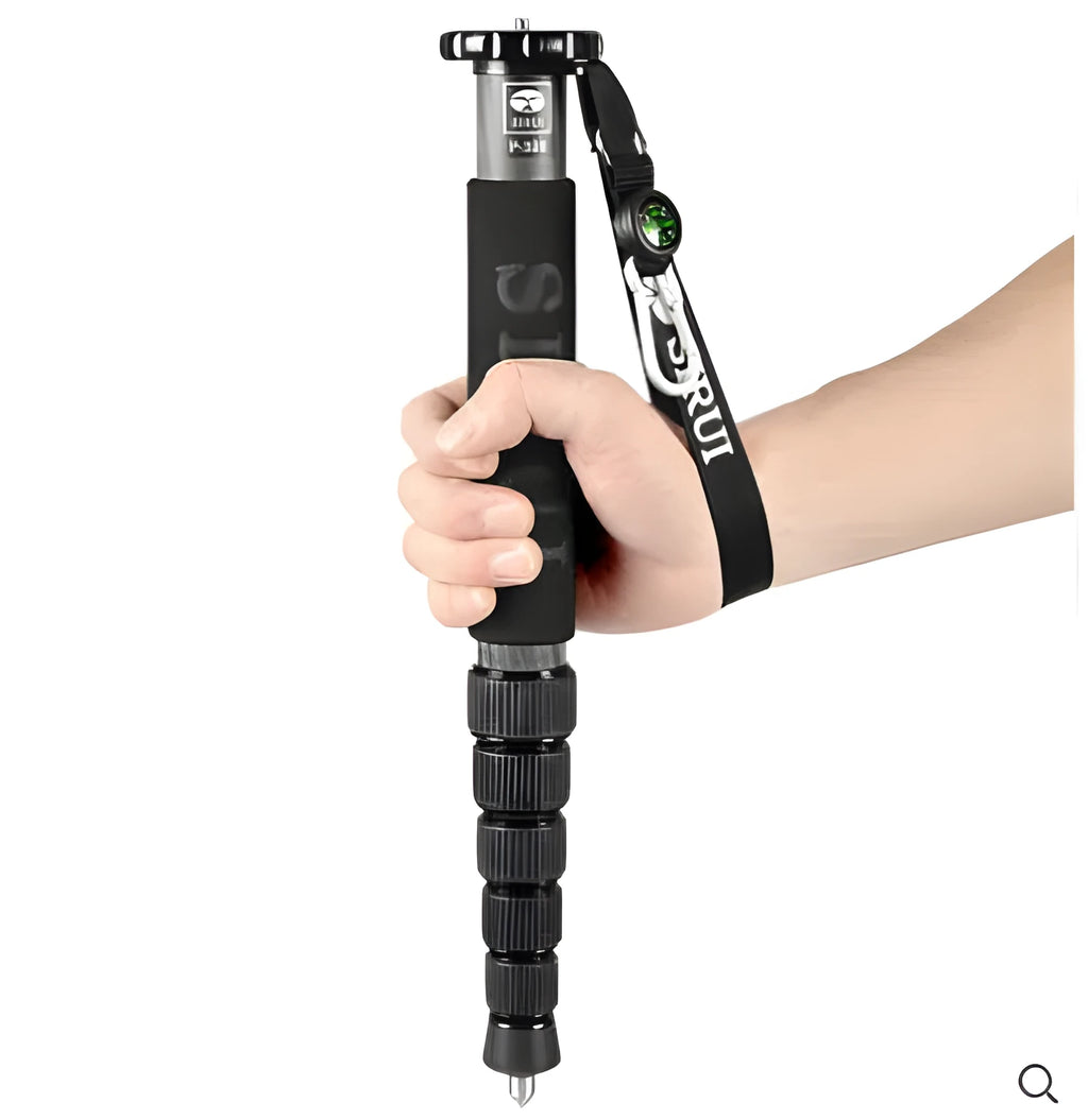 Black carbon fibre telescopic camera monopod fully extended next to a DSLR.