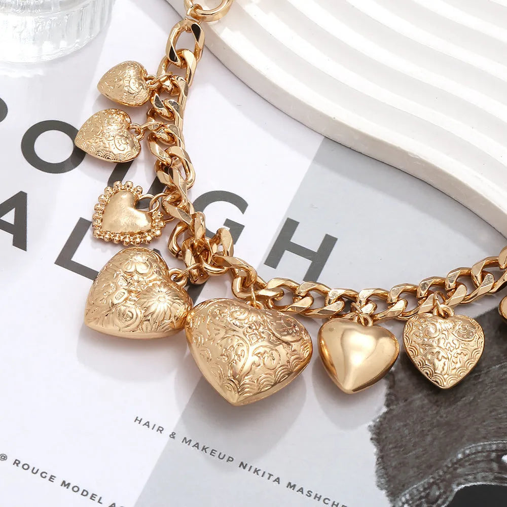 Exaggerated style gold heart pendant necklace with a regular chain on a plain background.