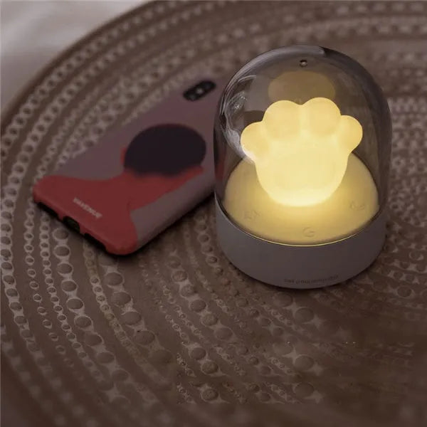 Grey cat paw shaped USB rechargeable night light with musical features on wooden desk