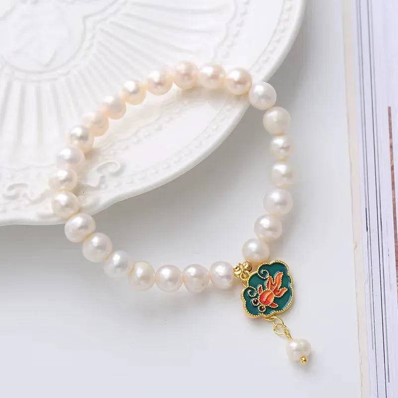 White vintage baroque bracelet with a freshwater pearl and goldfish lotus pendant.