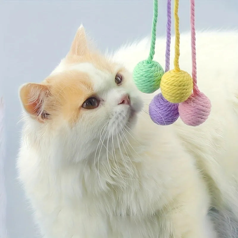 Colourful cat toy ball with an attached rope and built-in bell for kittens, shown in green, pink, purple, and yellow.