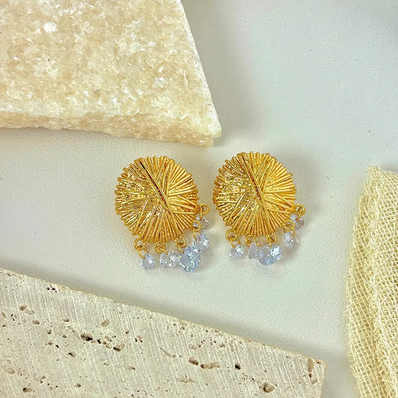 A pair of gold geometric metal earrings with round elements and an electroplated finish.