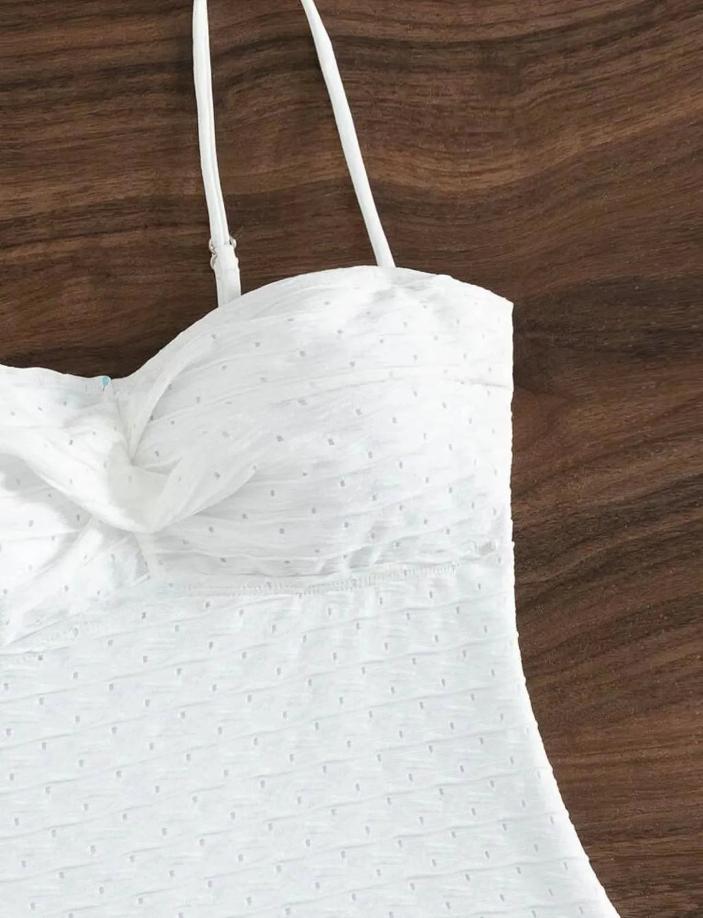 White women's one-piece swimsuit with a sling-style design made from high-elasticity polyester fabric.
