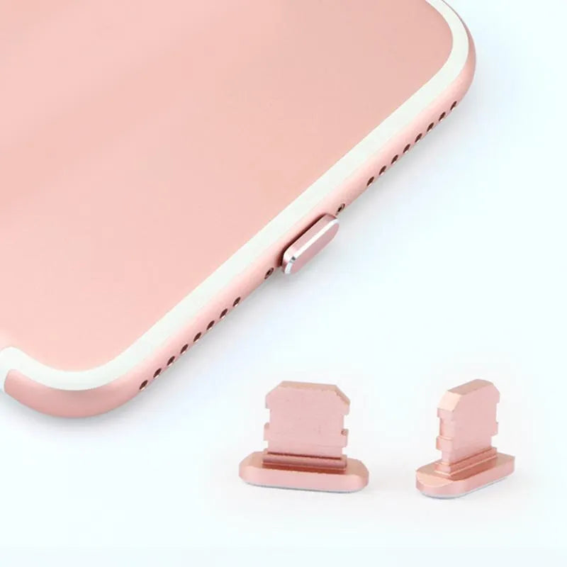Aluminum alloy iPhone charging port dust plug in rose gold colour on a grey background.