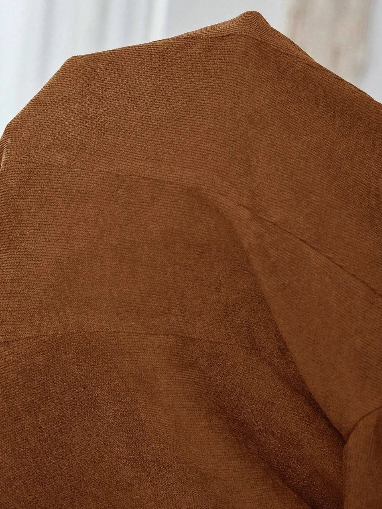 Brown men's single-breasted casual suit coat with long sleeves on a hanger