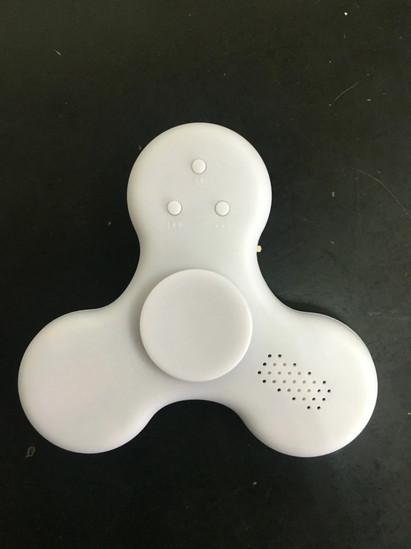 A square blue Bluetooth speaker and MP3 player with an integrated fidget spinner, showing button controls.