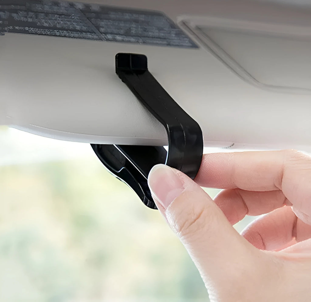 Black plastic multifunctional clip for car sunshades, holding sunglasses and a card.
