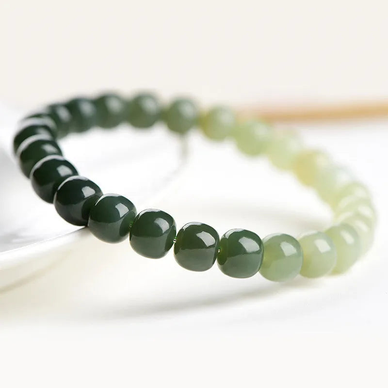 Natural Hetian Jade bracelet with gradient clear water colour on wrist, showing polished beads.
