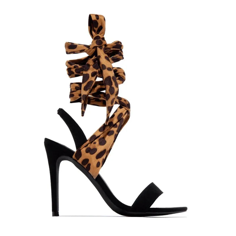 Light brown leopard print women's high heel sandals with crossover straps and a thin stiletto heel.