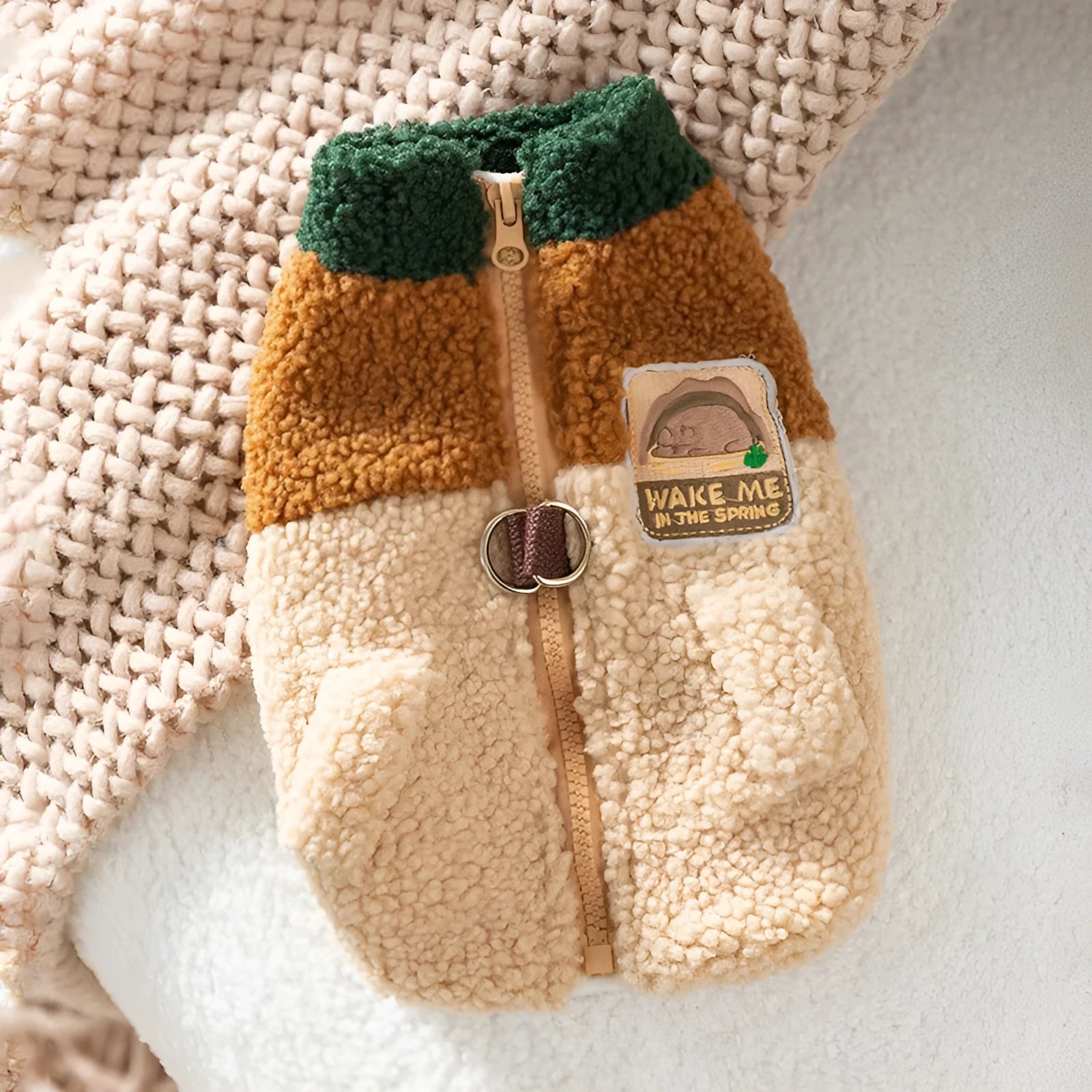 Colour-block pet fleece jacket with squirrel patch, leash ring, and pockets in green, brown, and beige on a small dog.
