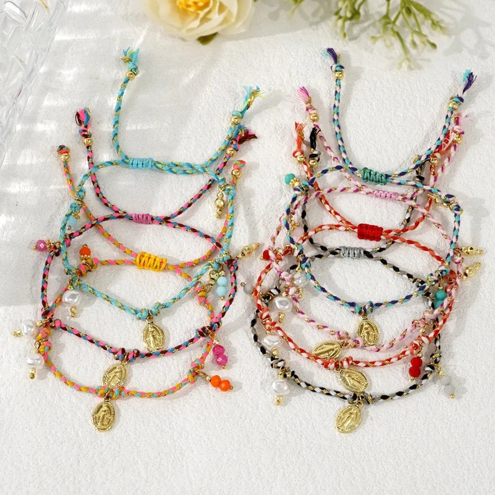 Close-up of a women's hand-woven ethnic bracelet made from colourful braided rope, showing the integrated carrying strap tag.