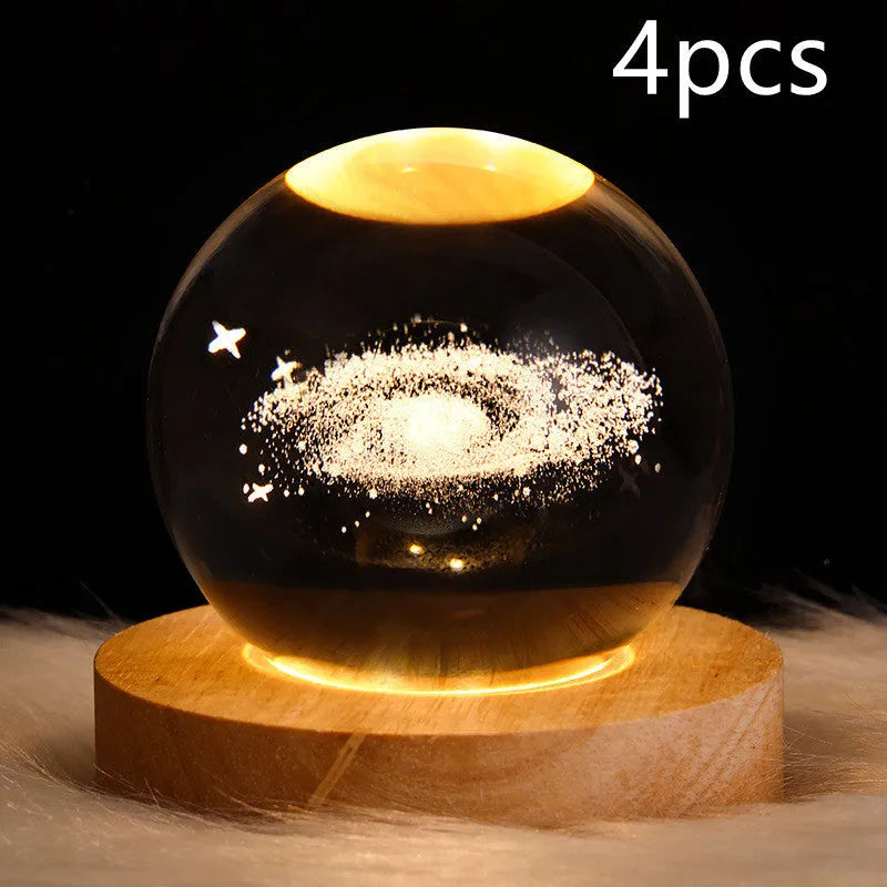 LED galaxy crystal ball night light with 3D planet designs on a table