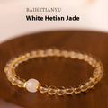 Close-up of a handmade adjustable bracelet made from natural rutilated quartz beads with golden rutile needle inclusions.