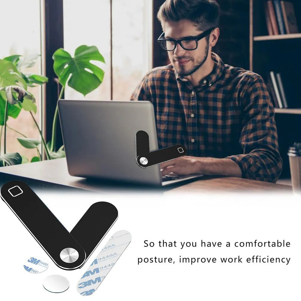 Black aluminium laptop phone holder with magnetic clip attached to a monitor, holding a smartphone