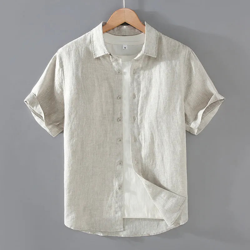 Man wearing a grey short-sleeved linen shirt in a casual cardigan style.
