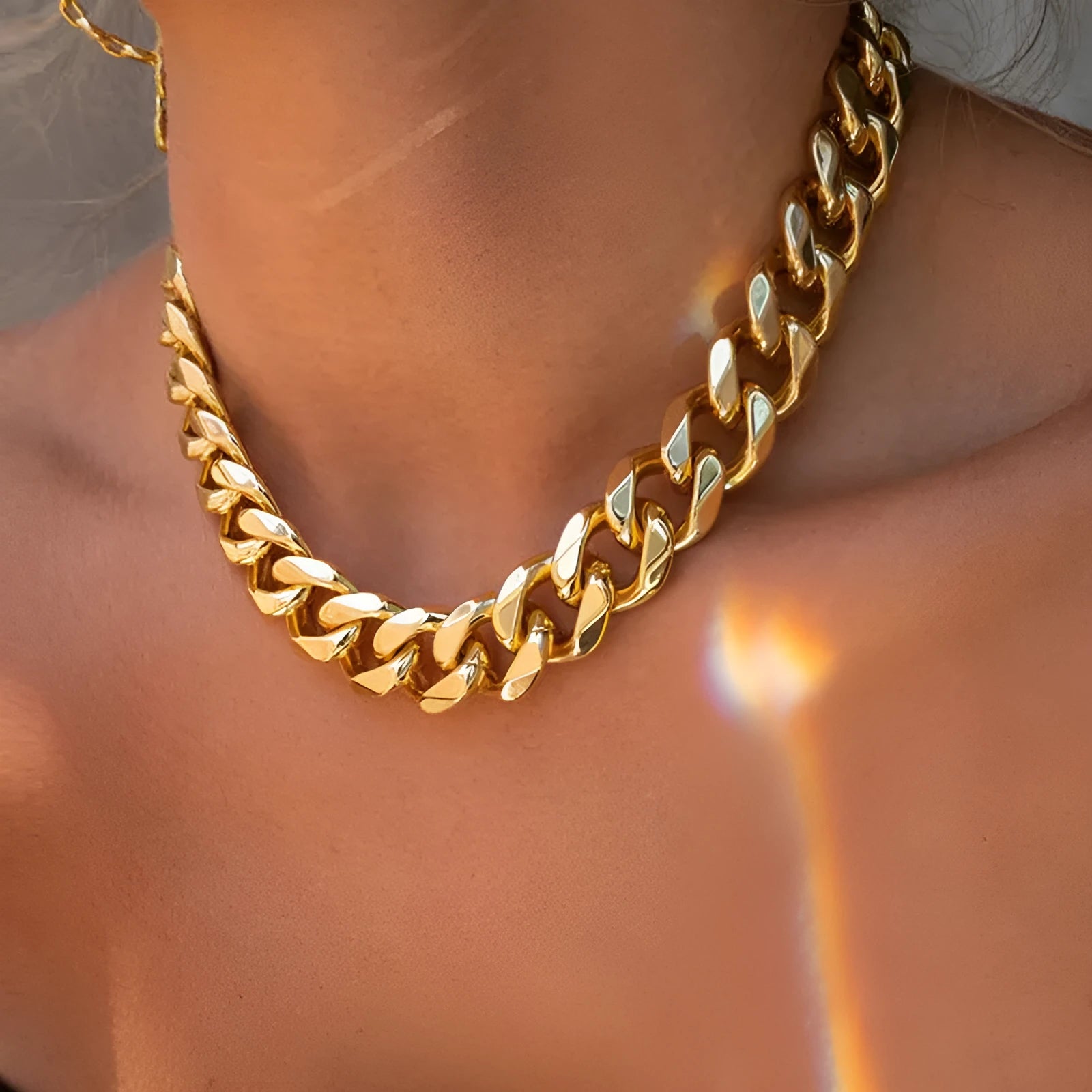 Women's gold tone thick chain necklace with a pendant on a white background.