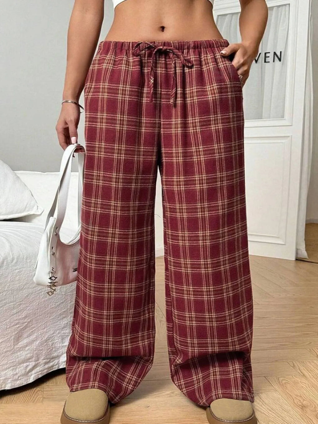 Blue plaid women's casual trousers with drawstring waist and pockets on a hanger.